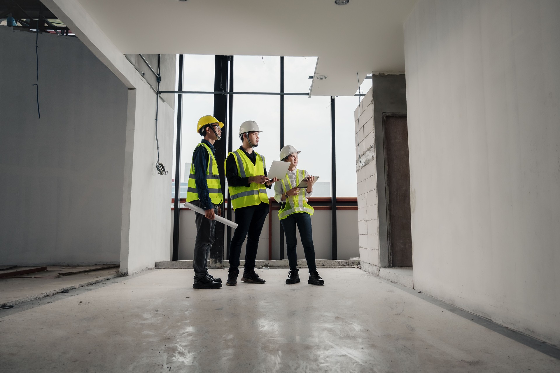 Engineer, architect and construction supervisor Use tablet to record information while inspecting construction work. Construction supervisor, architect or engineer inspect construction inside building