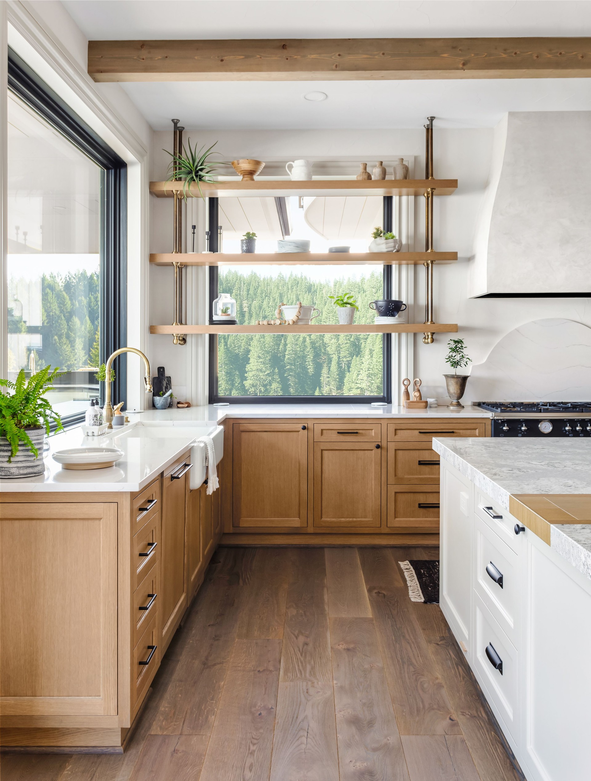 beautiful kitchen in new traditional style luxury home with island, pendant lights, and hardwood floors.