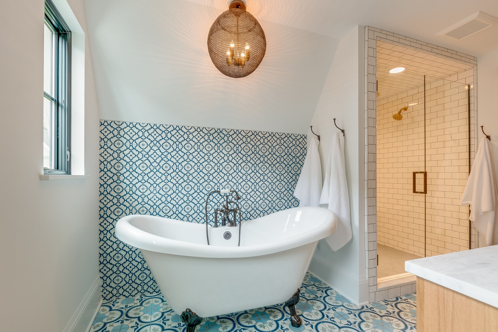 Blue and white patterned tile in bathroom with free standing bathtub